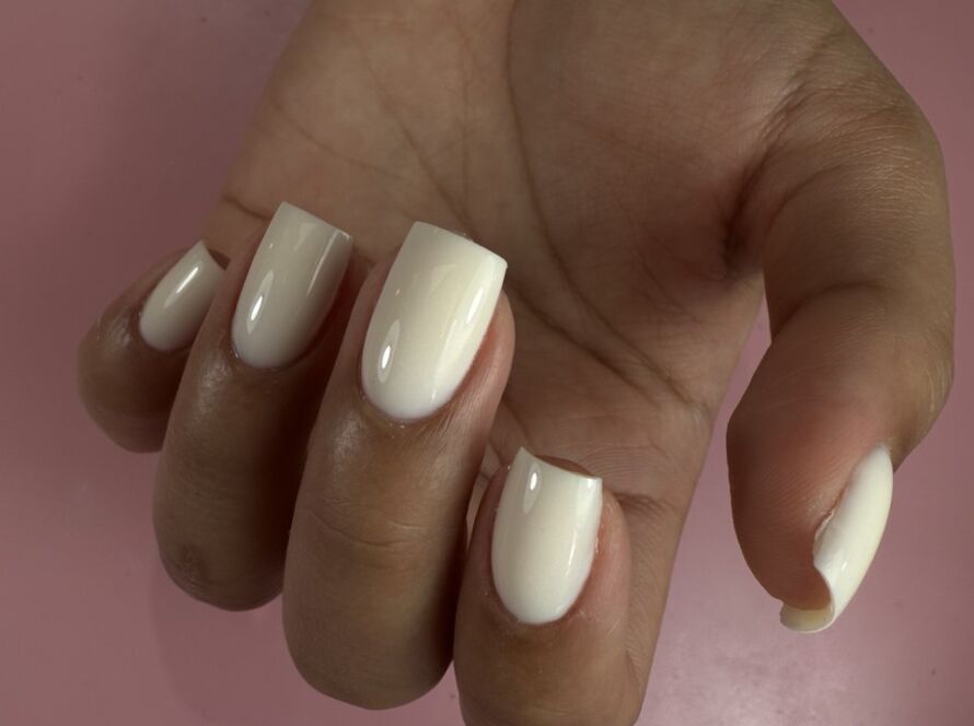 Short square milky white gel nails with a glossy finish, done using the Russian manicure technique.