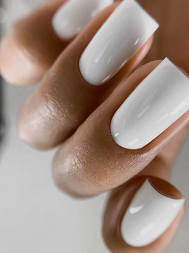 Glossy white square nails with a smooth, flawless finish, created using the Russian manicure technique