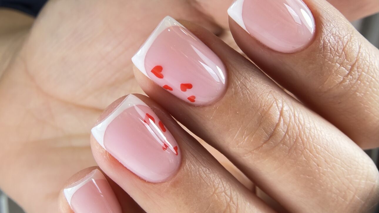 Russian manicure with white French tips and red heart nail art on short square nails