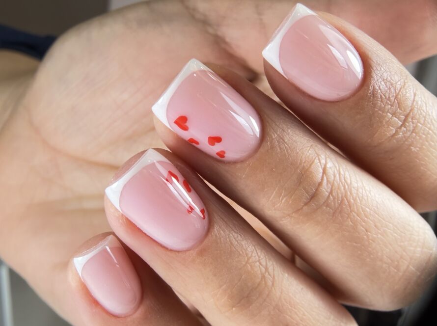 Russian manicure with white French tips and red heart nail art on short square nails